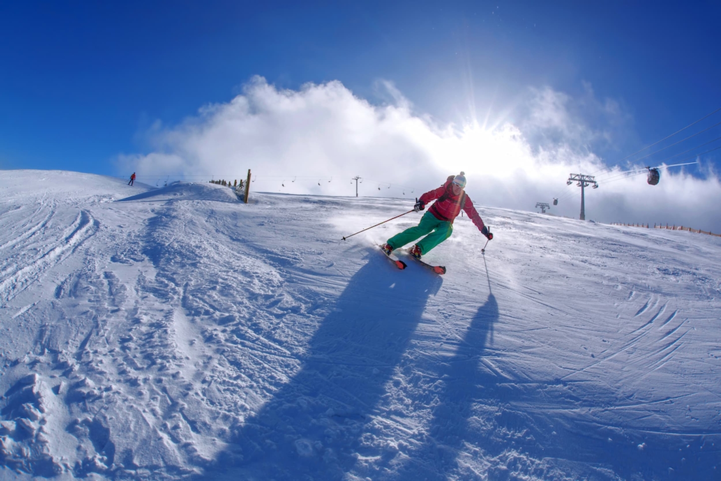 Person skiing down the mountain on a sunny day.