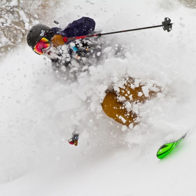 Skier skiing downhill through powdery snow